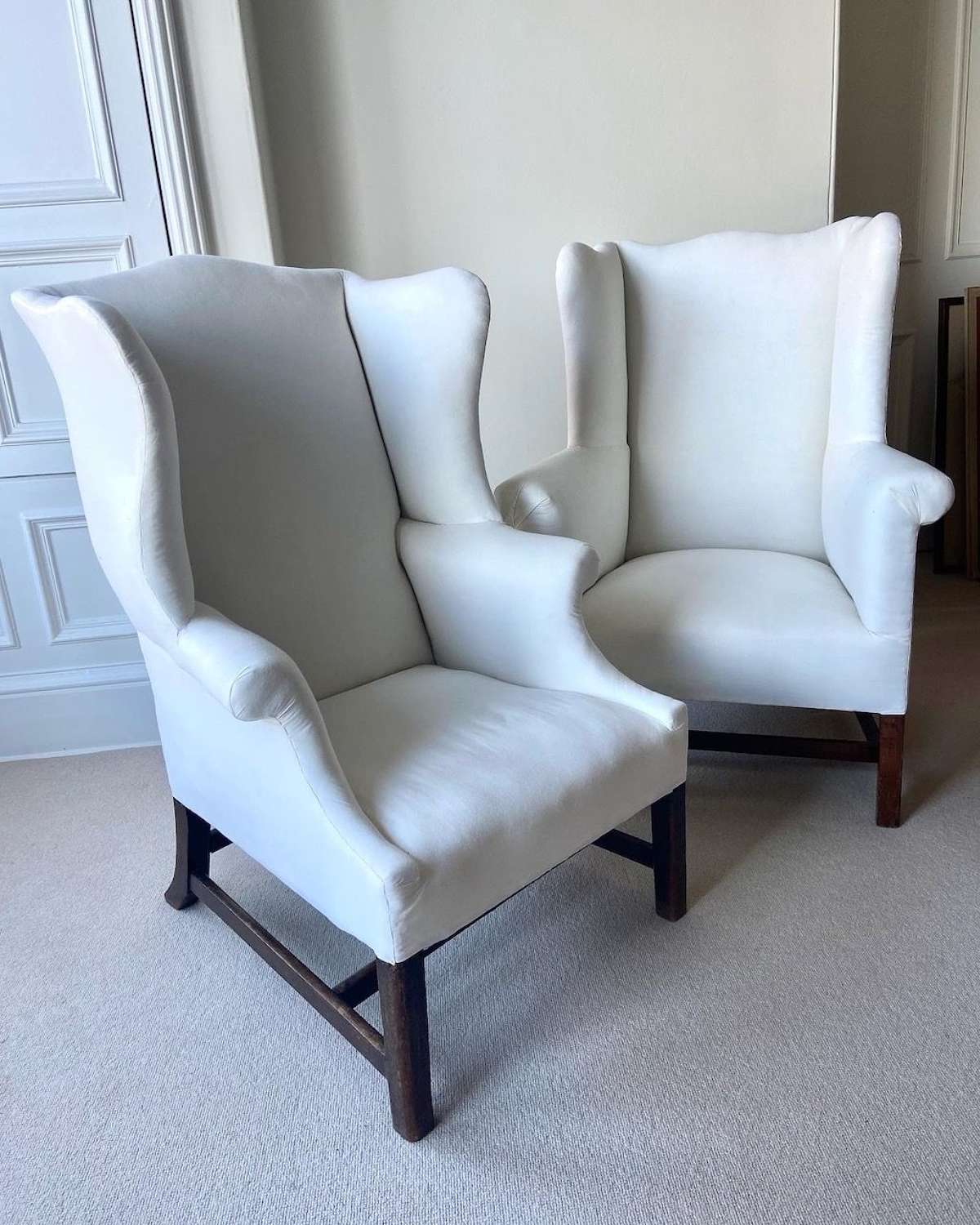 A matched pair of George III mahogany wing armchairs
